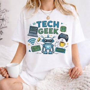Peut inclure: T-shirt blanc avec un motif color&eacute; "TECH GEEK" repr&eacute;sentant un robot, un ordinateur portable, une manette de jeu, un clavier et d'autres ic&ocirc;nes technologiques. Le design comprend des &eacute;l&eacute;ments bleus, verts, jaunes et noirs.