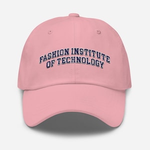 May include: A light pink baseball cap with the text "FASHION INSTITUTE OF TECHNOLOGY" in navy blue arched across the front. The cap has a curved brim and a button on top.