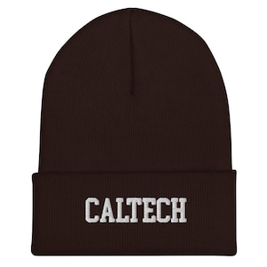 May include: A dark brown beanie hat with the word "CALTECH" embroidered in white across the front. The hat is made of a ribbed knit fabric.
