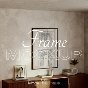 Puede incluir: Una impresión arquitectónica enmarcada con el texto "Frame Mockup" en blanco. La impresión se muestra en un mueble de madera oscura con objetos decorativos, incluyendo un pequeño espejo, libros y un jarrón con flores secas. La pared tiene un acabado texturizado y neutro.
