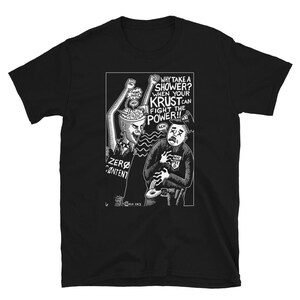 Può includere: T-shirt nero con grafica bianca. La grafica presenta due figure, una con la testa aperta e la scritta "ZERO CONTENT" sulla maglietta. L'altra figura è un poliziotto. Il testo sulla maglietta recita "WHY TAKE A SHOWER? WHEN YOUR KRUST CAN FIGHT THE POWER!!"