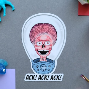 May include: A sticker featuring a cartoon Martian with a large brain, red eyes, and a blue collar. The sticker has the text "ACK! ACK! ACK!" in bold, black letters. The sticker is white with a clear border.