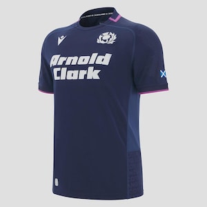 Könnte beinhalten: Marineblaues Sporttrikot mit weißem Text "Arnold Clark" und einem weißen Emblem. Das Trikot hat einen Rundhalsausschnitt mit rosa Besatz an Ärmeln und Kragen. Der Kragen zeigt den Text "Scotland & Scotland".