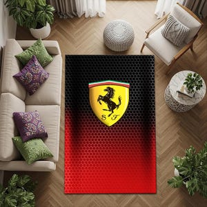 Puede incluir: Una taza de cerámica blanca con asa negra y el texto "But First, Coffee" en negrita negra. La taza se encuentra sobre un fondo borroso, sugiriendo un ambiente acogedor.