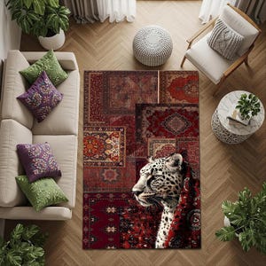 May include: A rectangular area rug with a patchwork design of various red and burgundy Persian rug patterns. A detailed leopard head is featured on the right side of the rug, with a red patterned shawl. The rug is placed on a wooden floor.