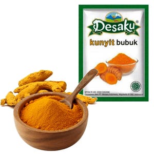 May include: A wooden bowl filled with bright orange turmeric powder and a wooden spoon, accompanied by raw turmeric roots. Next to it is a white packet labelled Desaku kunyit bubuk, featuring an illustration of turmeric powder and roots.