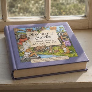 Könnte beinhalten: Ein Hardcover-Buch mit dem Titel "Treasury of Stories" von Beatrix Potter. Das Cover ist hellviolett mit einer farbenfrohen Illustration von Tieren. Das Buch liegt auf einer weißen Fensterbank.