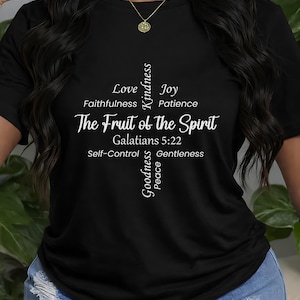 May include: Black t-shirt with white text. The text reads "The Fruit of the Spirit" with a cross-shaped design listing virtues like Love, Joy, and Patience. The scripture reference Galatians 5:22 is also included.