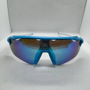 Op de afbeelding: Sport zonnebril met een blauw montuur en spiegelglazen. De zonnebril heeft een witte poot en een blauwe brug. De glazen reflecteren een kleurengradient. De tekst "Vista Market" is zichtbaar op de lens.
