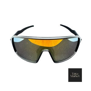 May include: Sport sunglasses with a black frame and orange-tinted lenses. The lenses have a reflective quality, and the frame features a sleek, modern design. The sunglasses are set against a white background.