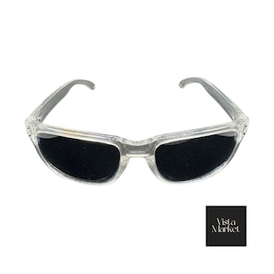 May include: Clear-framed sunglasses with dark lenses. The sunglasses have a rectangular shape and a transparent frame. The lenses are black and provide a contrast to the clear frame. The sunglasses are displayed on a white background.