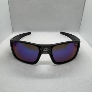 May include: A white ceramic mug with a black handle and the text "But First, Coffee" in a bold, black font. The mug is set against a blurred background, suggesting a cozy setting. The mug appears to be approximately 4 inches tall.