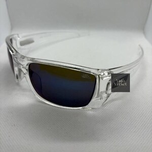 May include: Clear-framed sunglasses with dark blue lenses. The sunglasses have a rectangular shape and a sleek, modern design. The text "Vista Market" is visible on the right temple.