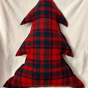 May include: A Christmas tree-shaped pillow in a red and green plaid pattern. The pillow is made of a soft fabric and has a three-dimensional design, perfect for holiday decor. The plaid pattern features a classic combination of red and green.