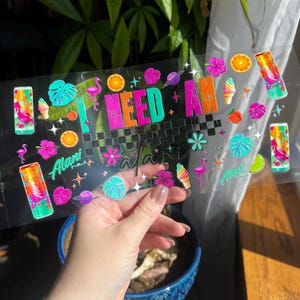 May include: A clear sticker sheet with colorful tropical-themed graphics. The text "I NEED A" is in bright colors, with additional illustrations of flamingos, ice cream cones, and fruit. The name "Alani" is also featured.