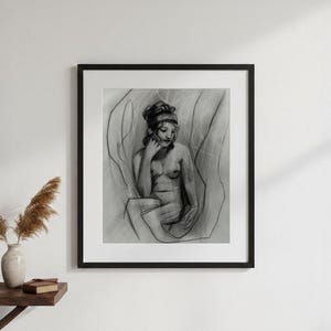 May include: A framed charcoal drawing of a seated figure. The artwork, rendered in shades of gray, depicts a woman with her hand to her face. The drawing is set against a backdrop of abstract lines, framed in a black border.