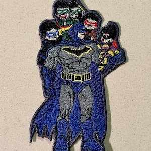 Puede incluir: Parche bordado con Batman con un traje azul y gris con un símbolo de murciélago amarillo. El parche incluye varias figuras de Robin, con varios disfraces, rodeando a Batman. El parche tiene un borde azul.