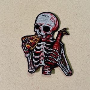 May include: Embroidered patch showing a skeleton eating pizza and holding a bottle. The skeleton is red, black, and white, with a detailed rib cage and skull. The pizza slice has yellow and red toppings. The bottle is red.