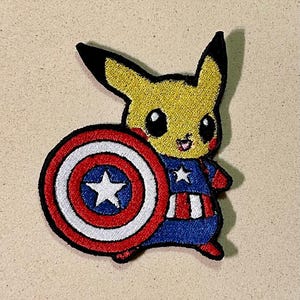 Peut inclure: Écusson brodé représentant Pikachu en Captain America. Le Pikachu jaune tient un bouclier avec une étoile blanche sur un fond rouge, blanc et bleu. Pikachu porte un costume bleu et rouge.