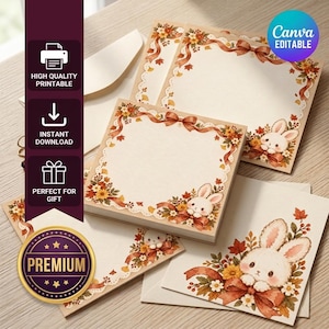 May include: A set of square stationery cards and envelopes featuring a cream-coloured background with a decorative border of autumn leaves, orange ribbons, and white flowers, accented by illustrations of small white rabbits with long ears.