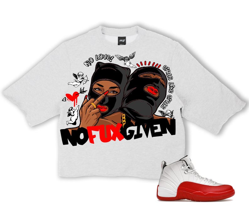 Puede incluir: Una camiseta gris claro de gran tama&ntilde;o con un gr&aacute;fico que presenta dos figuras con pasamonta&ntilde;as negros, labios rojos y cadenas doradas. La camiseta tiene el texto "NO LOVE! GIRLS LIKE GIRLS STOP GIVEN" y "NO FUX GIVEN". Una zapatilla deportiva blanca y roja est&aacute; en la parte inferior derecha.