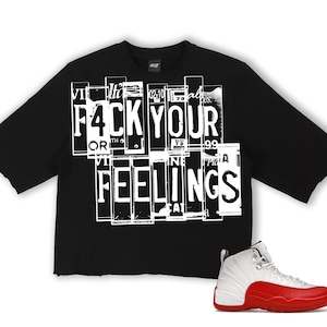Puede incluir: Camiseta negra de manga corta con el texto "F4CK YOUR FEELINGS" en blanco. Un par de zapatillas blancas y rojas est&aacute; en la esquina inferior derecha. La camiseta tiene un dobladillo sin rematar.