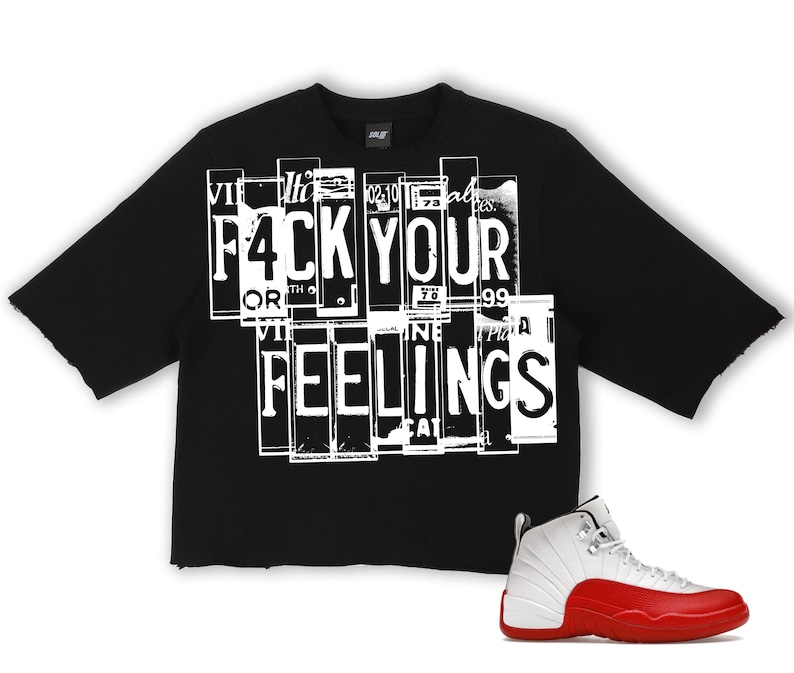 Puede incluir: Camiseta negra de manga corta con el texto "F4CK YOUR FEELINGS" en blanco. Un par de zapatillas blancas y rojas est&aacute; en la esquina inferior derecha. La camiseta tiene un dobladillo sin rematar.