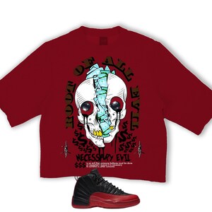 Puede incluir: Camiseta granate con un gr&aacute;fico de calavera con dinero y las palabras "DEATH" y "NECESSARY EVIL". Debajo, una zapatilla deportiva negra y roja.