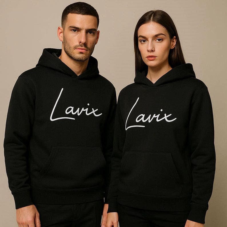 May include: Two black hoodies with the word "Lavix" in white script across the chest. The hoodies have a front pocket and a hood. The background is a solid, neutral color.