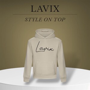 May include: A beige hoodie with a front pocket and a hood. The word "LAVIX" is printed at the top, with "STYLE ON TOP" below it. The word "Lavix" is written in cursive on the front of the hoodie.