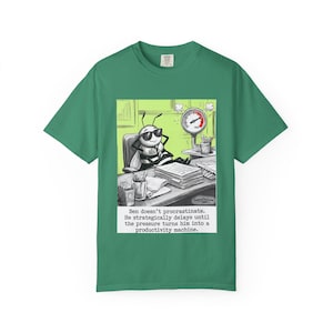 May include: Green t-shirt featuring a cartoon of a bee wearing sunglasses, sitting at a desk. The bee is surrounded by office supplies and a pressure gauge. Text on the shirt reads: "Ben doesn't procrastinate."