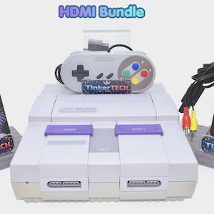 May include: A Super Nintendo game console bundle featuring a gray console with purple power and reset buttons, a gray controller with colored buttons, a Bitfunx HDMI adapter in its box, and a black power adapter with red and yellow RCA cables.