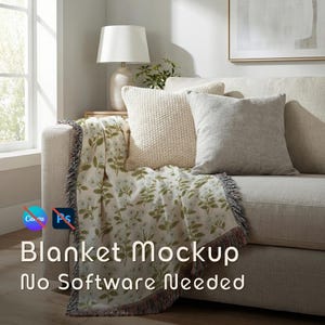 Könnte beinhalten: Ein beiges Sofa mit einer floral gemusterten Decke und zwei Kissen. Die Decke hat einen weißen Hintergrund mit grünen Blättern und Blumen. Die Kissen sind cremefarben und grau. Der Text auf der Decke lautet "Blanket Mockup No Software Needed."