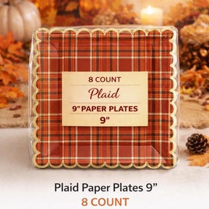 May include: A pack of eight plaid paper plates, each 23 cm in diameter. The plates have a red, orange, and brown plaid design with a scalloped edge. The packaging includes the text "Plaid" and "8 Count".