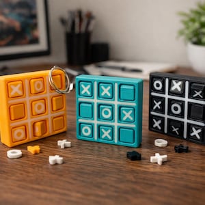 Könnte beinhalten: Drei farbenfrohe Tic-Tac-Toe-Spiele in Orange, Türkis und Schwarz. Jedes Spiel hat ein 3x3-Raster mit X's und O's. Das orangefarbene Spiel hat einen Schlüsselring. Lose Spielsteine ​​sind auf der Holzoberfläche verstreut. Ein lustiges, klassisches Spiel.