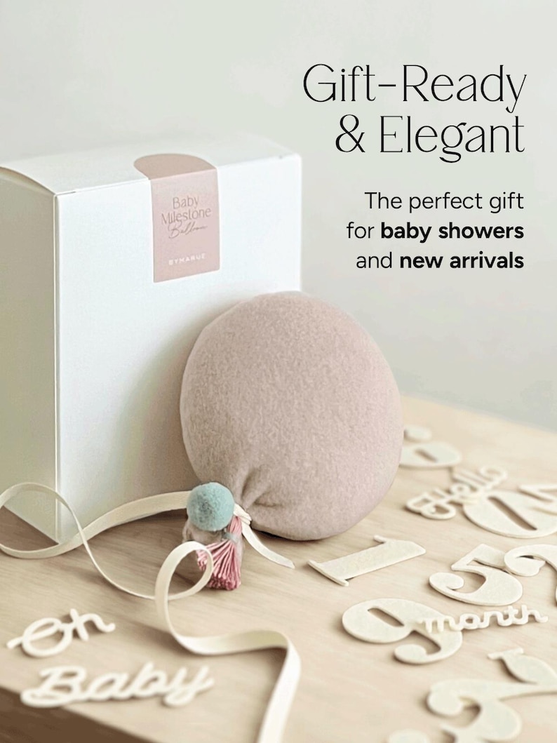 Balloon Baby Milestone Markers with interchangeable numbers and words that come in a gift-ready packaging. Soft neutral muted dusty pink with light blue. Gender-neutral unique baby shower gift idea.