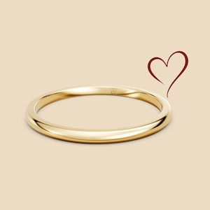 Peut inclure: Une bague en or avec une surface lisse et polie. La bague est posée sur un fond neutre avec une simple illustration de cœur. La bague mesure environ 0,25 cm de large.