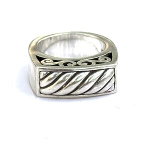 May include: A silver ring with a rectangular face and a twisted rope design. The ring features a decorative scrollwork pattern along the top edge. The ring is made of a shiny, metallic material.