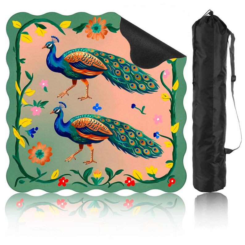 Op de afbeelding: Yogamat met een kleurrijke illustratie van twee pauwen met blauwe, turquoise, oranje en gele details. De mat heeft een groene rand met bloemaccenten en wordt geleverd met een zwarte draagtas.