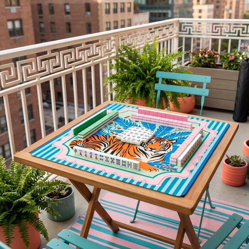 Puede incluir: Una mesa plegable de madera con un juego de Mahjong colorido. El tablero presenta un dise&ntilde;o de tigre con detalles en rosa, azul y verde. El juego incluye fichas verdes y rosas, sobre una alfombra a rayas azules y rosas.