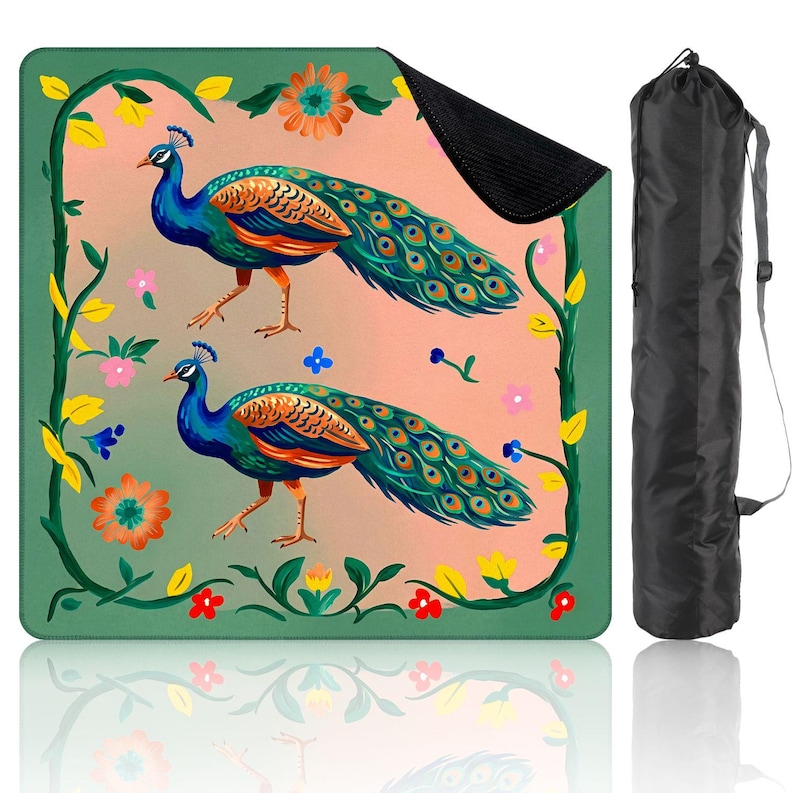Op de afbeelding: Een kleurrijke picknickdeken met twee pauwen met blauwe, oranje en groene veren. De deken heeft een roze achtergrond met bloemen- en wijnstokaccenten en een zwarte draagtas. Ontworpen voor buitengebruik, meet het ongeveer 150 cm x 150 cm.