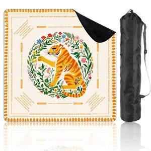 Peut inclure: Tapis carr&eacute; beige avec un tigre orange stylis&eacute; entour&eacute; d'une couronne florale. Le tapis comporte du texte en bordure et est livr&eacute; avec un sac de transport noir. Le motif du tigre est centr&eacute; sur le tapis.