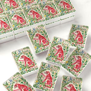 May include: A collection of rectangular white ceramic trays, each featuring a vibrant illustration of a pink tiger surrounded by colorful botanical elements, including green ferns, blue, yellow, and red flowers, arranged in a grid and scattered.