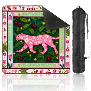 May include: A pink yoga mat with a floral design, featuring a pink leopard covered in white daisies. The mat is framed by a decorative border with cherries and flowers. Includes a black carry bag.