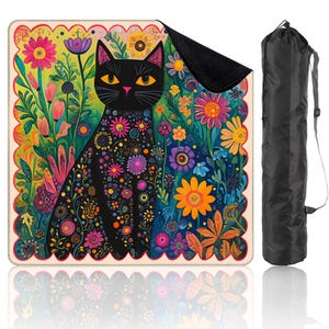May include: A yoga mat with a black cat design and floral patterns. The mat has a black backing and a black carry bag. The cat is surrounded by vibrant flowers in shades of pink, yellow, and blue. The mat is suitable for yoga.