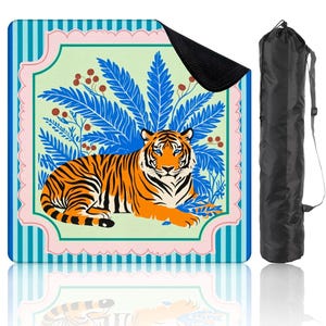 Peut inclure: Tapis de yoga carré avec une illustration de tigre orange et noir, aux yeux bleus, sur fond de feuillage bleu et de fond vert clair. Le tapis a une bordure rayée et est livré avec un sac de transport noir.
