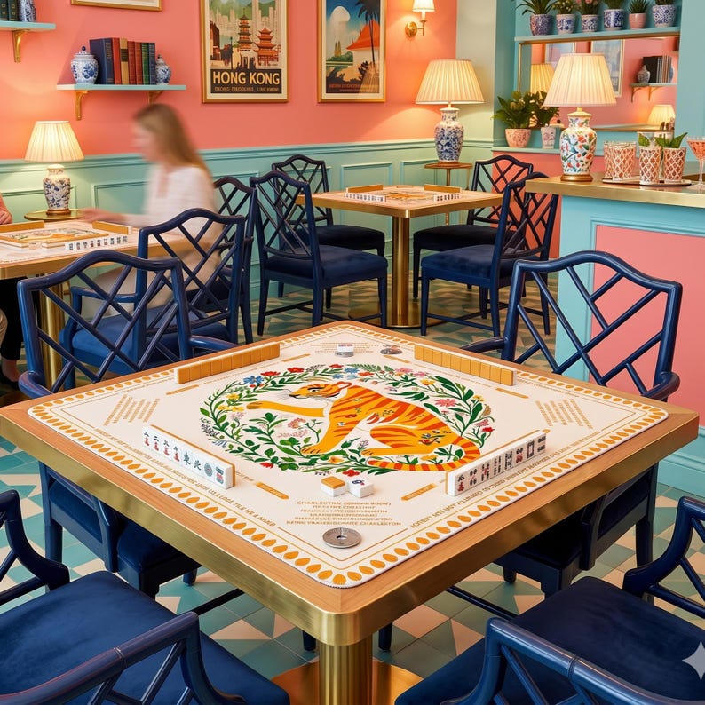 Peut inclure: Une table de mahjong carr&eacute;e avec un cadre dor&eacute; et une surface de jeu cr&egrave;me. La surface pr&eacute;sente une illustration de tigre entour&eacute;e de motifs floraux. Des chaises bleu fonc&eacute; entourent la table, et la pi&egrave;ce a une esth&eacute;tique r&eacute;tro.