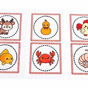 Puede incluir: Un conjunto de seis tarjetas ilustradas con animales y objetos de dibujos animados. Cada tarjeta tiene un fondo blanco, un borde rojo y un círculo punteado azul. Las ilustraciones incluyen un ciervo, una calabaza, un gallo, un pez dorado, un cangrejo y un camarón.