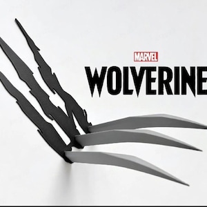 May include: A black wall-mounted decoration featuring three jagged claw marks and three protruding silver-colored blades. The text MARVEL WOLVERINE is printed in black and red above the blades, creating a sharp, dimensional graphic display.