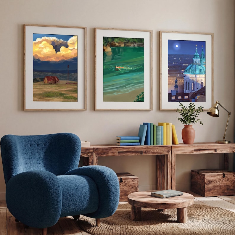 Puede incluir: Tres impresiones art&iacute;sticas enmarcadas con escenas de paisajes. Una representa una puesta de sol sobre un campo con un edificio, otra muestra a una persona nadando en agua verde y la tercera presenta un paisaje urbano nocturno. Las impresiones se exhiben sobre una consola de madera.